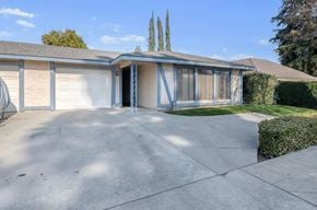 Fresno apartment for rent - A house with a driveway and a tree in the background.