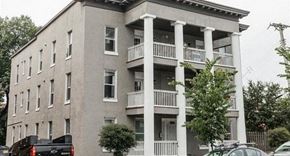 Minneapolis apartment for rent - A grey building with white columns and balconies.