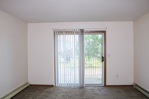 Fargo apartment for rent - an empty living room with sliding glass doors to a patio