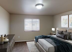 West Fargo townhouse for rent - A bedroom with a bed, nightstand, and window.
