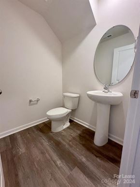 Charlotte house for rent - A bathroom with a toilet, sink, and mirror.