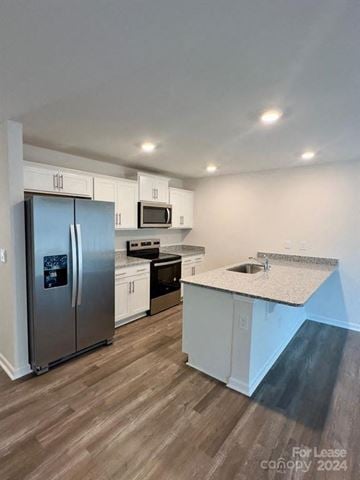Charlotte house for rent - A kitchen with a refrigerator, microwave, and oven is for lease in 2024.