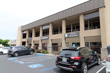 Chula Vista apartment for rent - A black car is parked in a parking lot in front of a building with a sign that says Property Management.