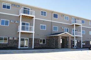 Moorhead apartment for rent - an exterior view of an apartment building with balconies and a door