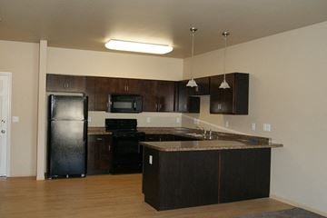 Moorhead apartment for rent - an empty kitchen with black appliances and a counter top