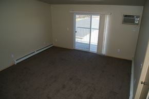 Moorhead apartment for rent - an empty living room with a door to a balcony