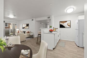 Reno apartment for rent - A modern kitchen and living room with a dining table set for two.