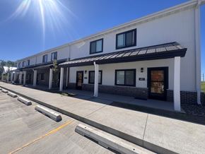 Grinnell apartment for rent - A white building with a black awning and a yellow line on the street in front.