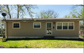 St. Louis house for rent - A beige house with a black door and windows.