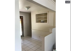 St. Louis house for rent - A white hallway with a door and a window.