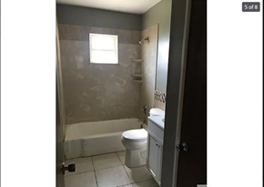 St. Louis house for rent - A bathroom with a toilet, sink, and shower.