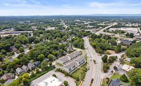 Greenville house for rent - A bird's eye view of a suburban area with roads, houses, and trees.