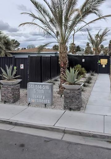 Las Vegas apartment for rent - A sign for Luxury Apartments is displayed in front of a black fence.