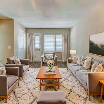 Nashville apartment for rent - A living room with a grey couch, a wooden coffee table, and a large painting on the wall.