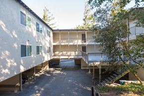 San Bruno apartment for rent - an image of an apartment building with stairs and a courtyard