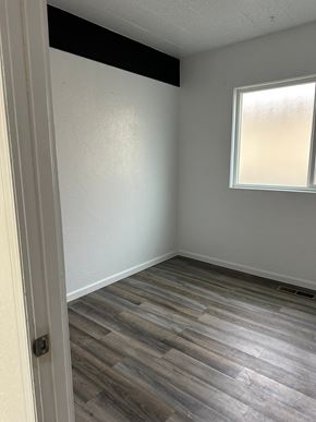 Grandview house for rent - A room with a window and wooden flooring.