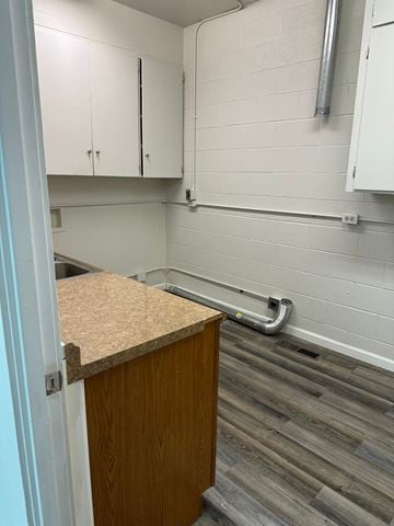 Grandview house for rent - A kitchen with white cabinets and a wooden counter.