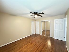 Fayettevillle house for rent - A room with a ceiling fan and wooden floors.