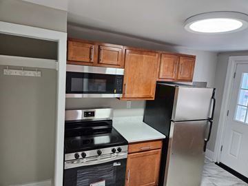 Frederick apartment for rent - A kitchen with a black refrigerator and stove.