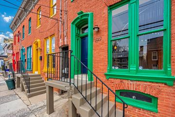 Frederick apartment for rent - A red brick building with green trim and a blue door.