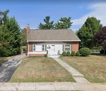 Frederick apartment for rent - A small house with a white door and a brick chimney.