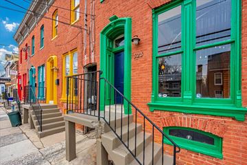 Frederick apartment for rent - A red brick building with green trim and a blue door.