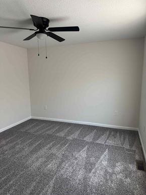 Mccomb apartment for rent - A room with a ceiling fan and carpeted floor.