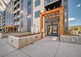 Calgary apartment for rent - A modern building with a wooden entrance gate and planters in front.