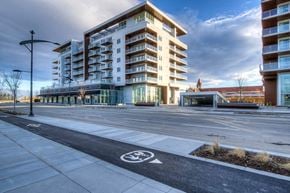 Calgary apartment for rent - A modern building with a bicycle lane in front.
