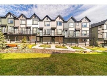 Calgary apartment for rent - A row of modern townhouses with balconies and front yards.
