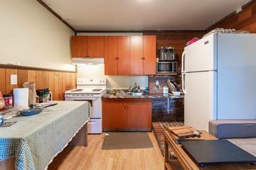 Victoria apartment for rent - A kitchen with wooden cabinets and a white fridge.