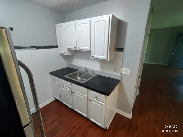 Norwood apartment for rent - A kitchen with white cabinets and a black countertop.