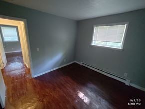 Norwood apartment for rent - A room with a wooden floor and a window with blinds.