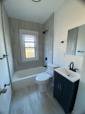 Louisville apartment for rent - A bathroom with a white tub, toilet, and sink.