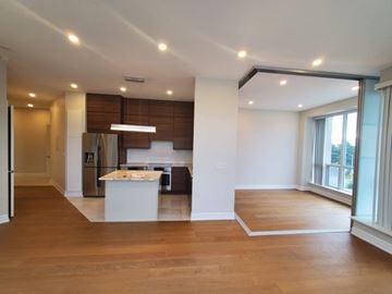 Toronto apartment for rent - A spacious kitchen with a refrigerator, sink, and stove is located in the center of the room.