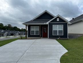 Little Rock house for rent - A house with a grey front yard and a red door.