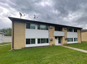 Fargo apartment for rent - A building with a grey roof and white walls has two satellite dishes on top.