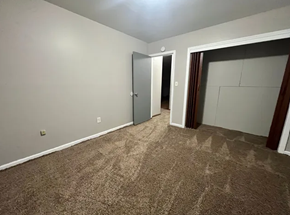 Fargo apartment for rent - A room with a carpeted floor and a door on the left side.