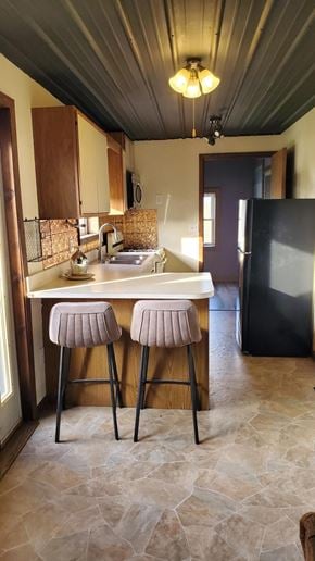 Ligonier house for rent - A kitchen with a bar stool and a fridge.