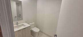 Hamilton apartment for rent - A white toilet sits next to a sink in a small bathroom.