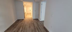 Hamilton apartment for rent - A long hallway with white walls and wood flooring.