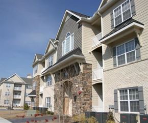 Greenville condo for rent - A large apartment building with a stone chimney and balconies.