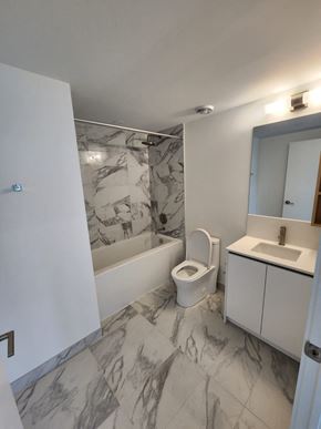 Toronto apartment for rent - A bathroom with a marble floor and white walls.