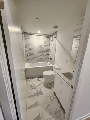 Toronto apartment for rent - A white bathroom with a marble tile floor.