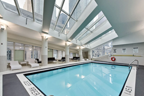 Toronto apartment for rent - A swimming pool inside a building with a glass ceiling.