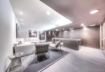 Toronto apartment for rent - A modern living room with a white sofa and a grey chair.