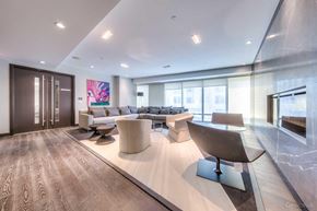 Toronto apartment for rent - A modern living room with a wooden floor and a large abstract painting on the wall.