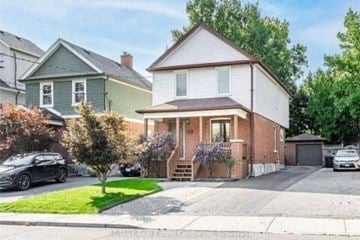 Toronto house for rent - A house with a white garage door and a brown roof.