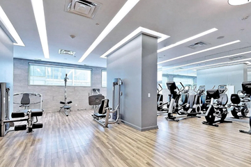 Toronto apartment for rent - A gym with a variety of equipment including treadmills, weights, and exercise machines.