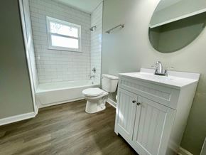 Louisville house for rent - A white bathroom with a toilet, sink, and tub.